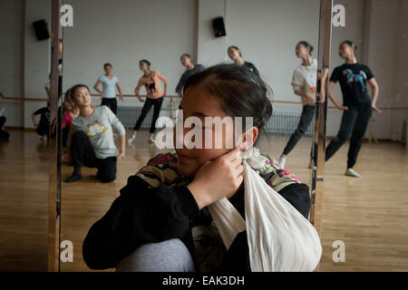 (141117)--YINCHUAN, 17. November 2014 (Xinhua)--Foto am 29. Oktober 2014 zeigt eine verletzte Mädchen beobachten ihre Klassenkameraden üben einen traditionellen Tanz der Hui ethnische Gruppe in einer Klasse in Ningxia Arts School in Yinchuan, der Hauptstadt der nordwestlichen China Ningxia Hui autonome so Mädchen, die in den traditionellen Tanz seit fünf Jahren ausgebildet wurden, sind bemüht für die bevorstehenden Abschluss-Performance. Der Kurs des traditionellen Tanzes, ist auch die einzige bundesweit wurde von Ningxia Arts School vor über drei Jahrzehnten initiiert. Bereits in den 1950er-Jahren ein Ältester gen Stockfoto