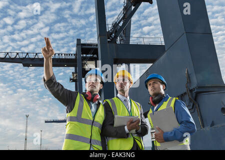 Unternehmer und Arbeitnehmer sprechen in der Nähe von Fracht Kran Stockfoto