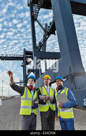 Unternehmer und Arbeitnehmer sprechen in der Nähe von Fracht Kran Stockfoto