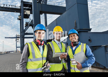 Arbeitnehmer und Unternehmer, die lächelnd in der Nähe von Fracht Kran Stockfoto