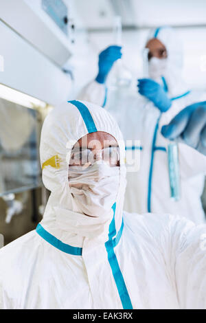 Wissenschaftler in sauberen Anzug Reagenzglas im Labor untersuchen Stockfoto