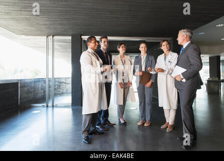 Wissenschaftler und Geschäftsleute sprechen in lobby Stockfoto