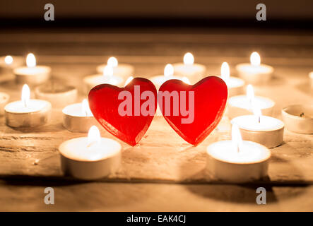 kleine rote Holzherzen und Kerzen Stockfoto