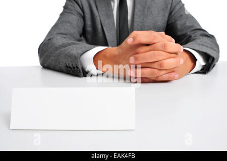 ein Mann in einem Anzug sitzt in einem Schreibtisch mit einem leeren Schild vor ihm mit einem Textfreiraum Stockfoto