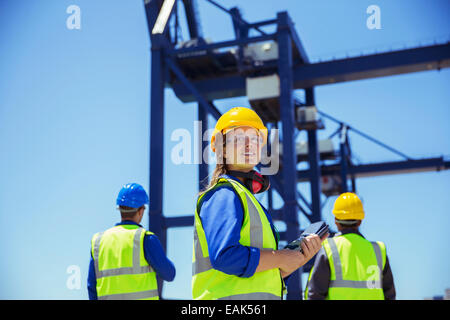 Niedrigen Winkel Ansicht der Arbeitnehmer unter Ladung Kran steht Stockfoto