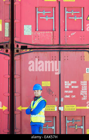 Arbeiter in der Nähe von Frachtcontainern lächelnd Stockfoto