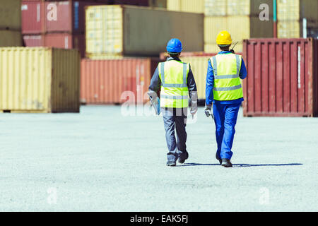 Arbeiter zu Fuß in der Nähe von Containern Stockfoto