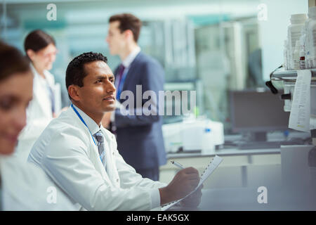 Wissenschaftler, die Notizen auf Experiment im Labor Stockfoto