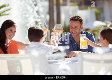 Familie mit zwei Kindern, die Erhöhung der Toast am Tisch im freien Stockfoto