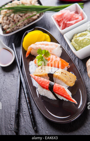 Verschiedene Arten von Sushi Essen serviert auf schwarzem Stein Stockfoto