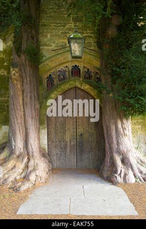 Alte Eibe Bäume wachsen im Nordportal, St. Edwards Church, Stow-on-the-Wold, Gloucestershire, Cotswolds, England, UK, GB Stockfoto