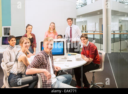 Gruppenbild von Jugendlichen Studenten mit ihrem Lehrer am Tisch Stockfoto