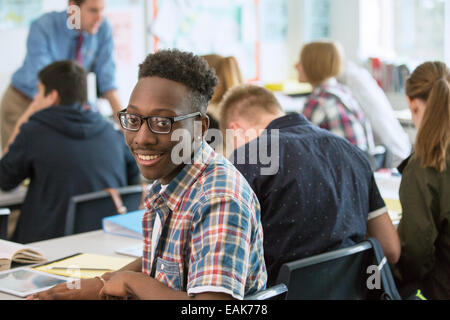 Lächelnd und selbstbewusst Schüler mit Lehrer im Klassenzimmer Stockfoto