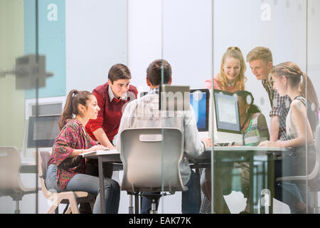 Schüler arbeiten mit Computern hinter Glastür Stockfoto