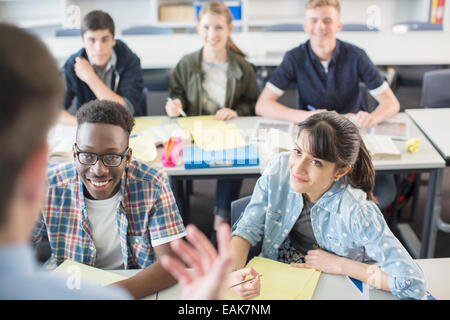 Fröhlich-Schülerinnen und Schüler im Klassenzimmer sitzen Stockfoto
