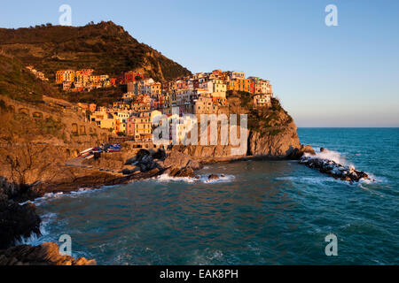 Häuser von Manarola an der felsigen Küste im Abendlicht, UNESCO Weltkulturerbe, Manarola, Cinque Terre, Ligurien Stockfoto