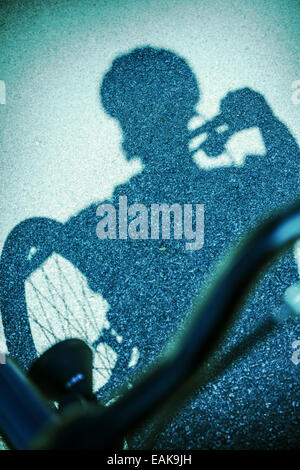 Schatten Sie auf Straße von Mann mit dem Fahrrad Stockfoto