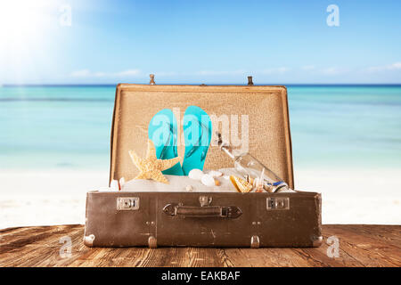 Konzept des Sommers Reisen mit alten Koffer und Zubehör. Strand auf Hintergrund Unschärfe Stockfoto