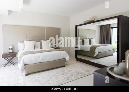 Weiße und Beige modernes Schlafzimmer mit Doppelbett-Spiegel Stockfoto