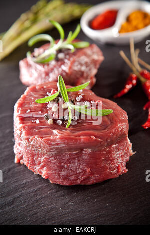 Stück rot rohes Fleisch Steak, serviert auf schwarzem Steinoberfläche. Stockfoto