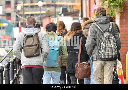 Bristol, UK. 17. November 2014. Studenten gesehen ein Spaziergang entlang der schwimmenden Harbourside in Bristol auf einem nassen und windigen Tag. Bildnachweis: Robert Timoney/Alamy Live-Nachrichten Stockfoto