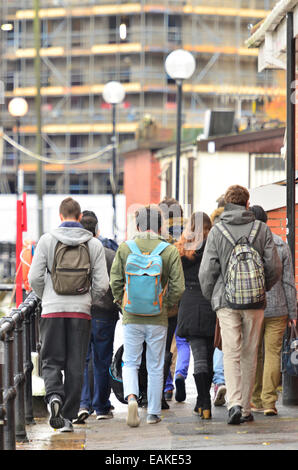 Bristol, UK. 17. November 2014. Studenten gesehen ein Spaziergang entlang der schwimmenden Harbourside in Bristol auf einem nassen und windigen Tag. Bildnachweis: Robert Timoney/Alamy Live-Nachrichten Stockfoto