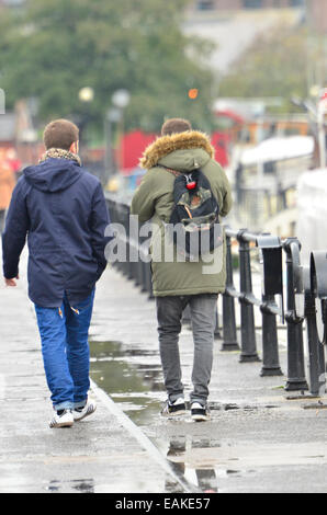 Bristol, UK. 17. November 2014. Studenten gesehen ein Spaziergang entlang der schwimmenden Harbourside in Bristol auf einem nassen und windigen Tag. Bildnachweis: Robert Timoney/Alamy Live-Nachrichten Stockfoto