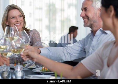 Menschen, die Erhöhung eines Toast mit Weißwein im restaurant Stockfoto