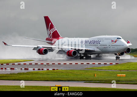 Virgin Atlantic-Boeing 747-400 bremst auf der Piste 23R nach einem schweren Regenschauer am Manchester Airport. Stockfoto