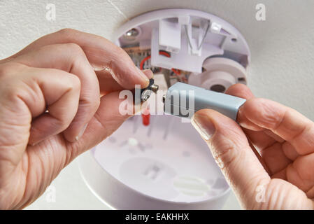 Nahaufnahme von Batteriewechsel In häusliche Rauchmelder Stockfoto