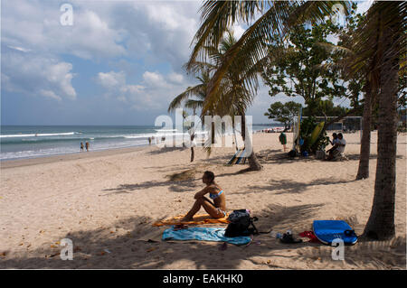 Indonesien, Bali, Kuta, Strand, Frau Sonnenbaden.  Sonnenbad am Strand von Kuta. Surfunterricht. Bali. Kuta ist eine Küstenstadt in Stockfoto