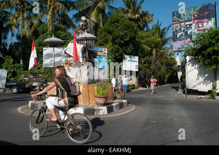 Ein Tourist mit dem Fahrrad in Kuta Straße. Surfbrett in den Straßen von Kuta Beach. Bali. Die meisten Lomboks Südküste Angebot suchen Surf- Stockfoto