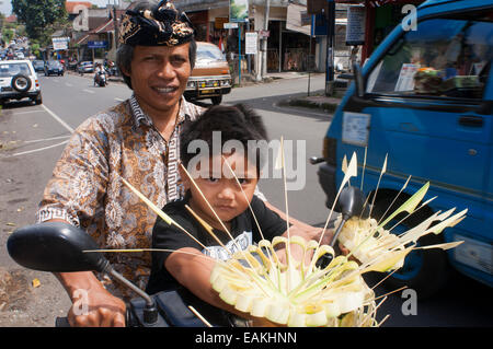 Vater mit seinem Sohn in ein Motorbyke. Hinduistische Rituale und feiern im Tempel in der Nähe von Kuta. Bali. Galungan feiern Bali Ind Stockfoto