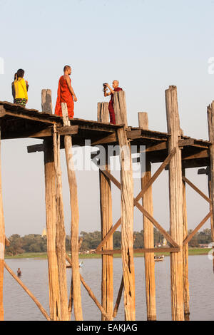 Sonnenuntergang. Buddhistische Mönche fotografieren. Kreuzung U Bein Brücke Teakholz über Taungthaman-See, in der Nähe von Mandalay, Myanmar, Burma, Myanmar Stockfoto