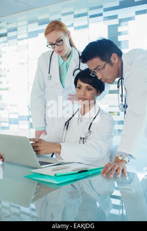 Ärzte mit Laptop und Diskussion über die Behandlung der Patienten Stockfoto