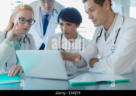 Ärzte mit Laptop und Diskussion über die Behandlung der Patienten Stockfoto