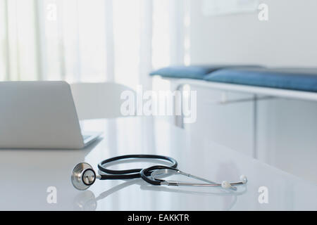 Stethoskop und Laptop auf weißen Schreibtisch in Arztpraxis Stockfoto