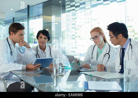 Ärzte mit Laptop und Diskussion über die Behandlung der Patienten Stockfoto