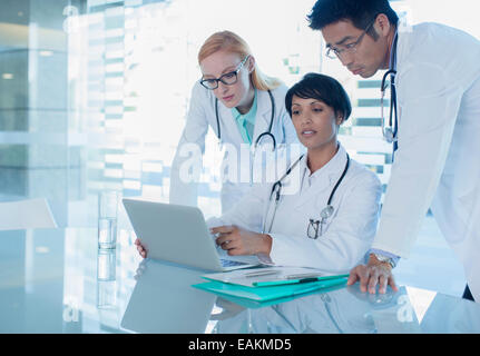 Ärzte mit Laptop und Diskussion über die Behandlung der Patienten Stockfoto