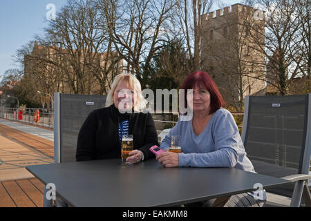 Passagiere genießen Sie einen Drink unter dem strahlend blauen Himmel auf dem oberen Deck eines Kreuzfahrtschiffes Viking River in Regensburg, Deutschland Stockfoto