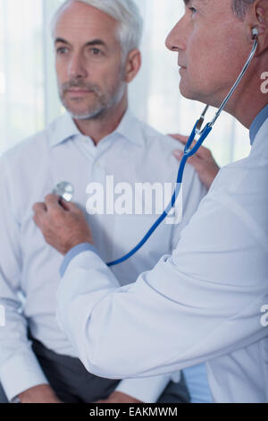 Arzt untersuchen Patienten mit Stethoskop im Büro Stockfoto