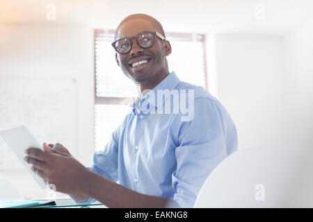 Porträt des jungen Geschäftsmann Brillen-und blaues Hemd mit digital-Tablette in Büro Stockfoto