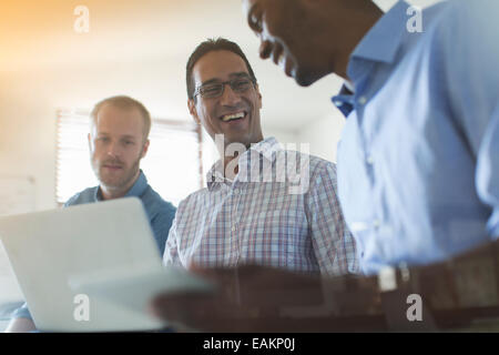 Männer mit digitalen Tablet und Laptop im Büro Stockfoto