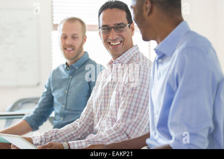 Drei lachende Männer arbeiten zusammen im Büro Stockfoto