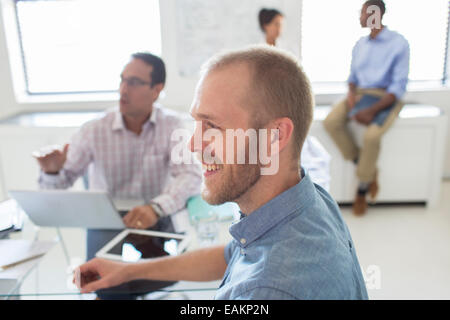 Lächelnde Menschen während der Sitzung im Büro Stockfoto