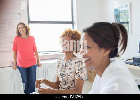 Drei Frauen, die während der Sitzung im Büro lachen Stockfoto