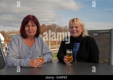 Passagiere genießen Sie einen Drink unter dem strahlend blauen Himmel auf dem oberen Deck eines Kreuzfahrtschiffes Viking River in Regensburg, Deutschland Stockfoto