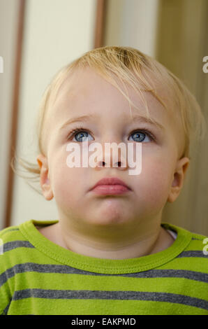 Eine nachdenkliche aussehende blond und blauäugig Baby Boy (ca. 18 Monate alt). Stockfoto