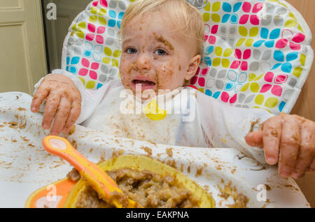 Ein kleinen Jungen (ca. 18 Monate alt) macht ein heilloses Durcheinander seine Mahlzeit. Stockfoto