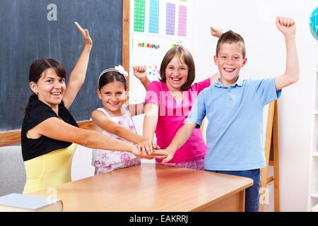 Glückliche Gewinner Gruppe vereint Studenten und Lehrer in der Schule, Erziehung und Hand in Hand zusammen Stockfoto